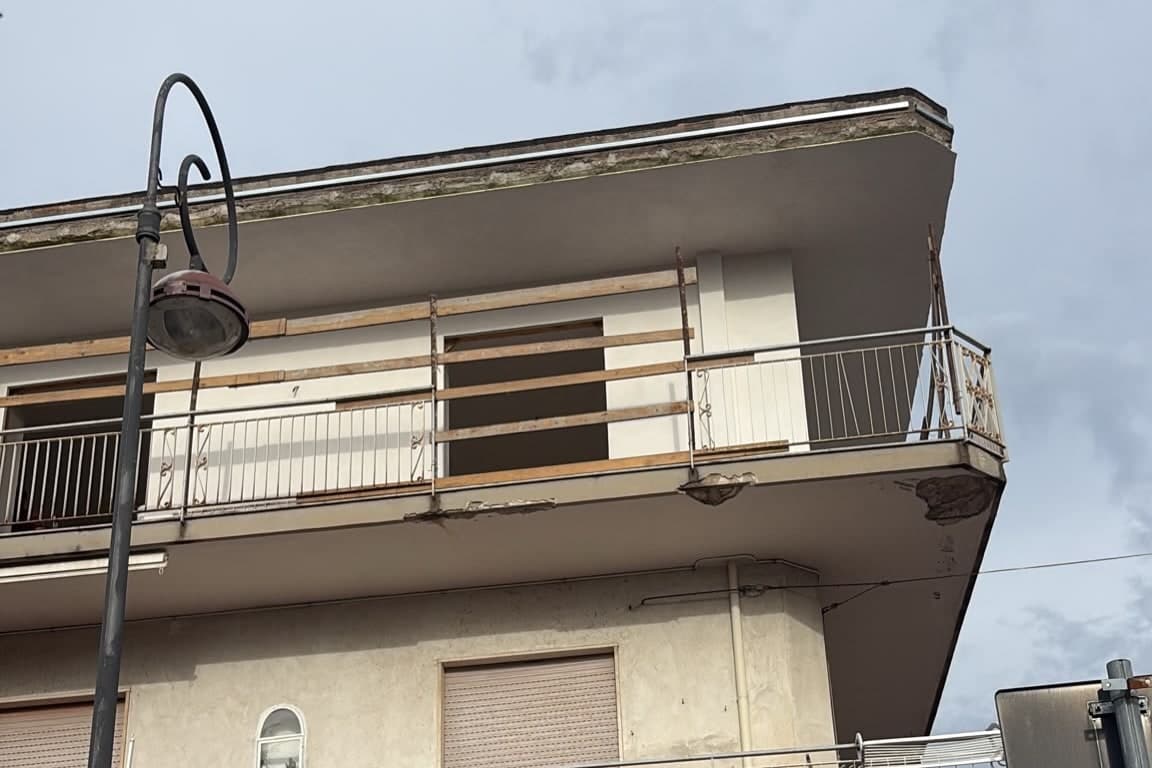 Prima dei lavori: edificio visto dalla strada, con il bordo della soletta di copertura rovinato.