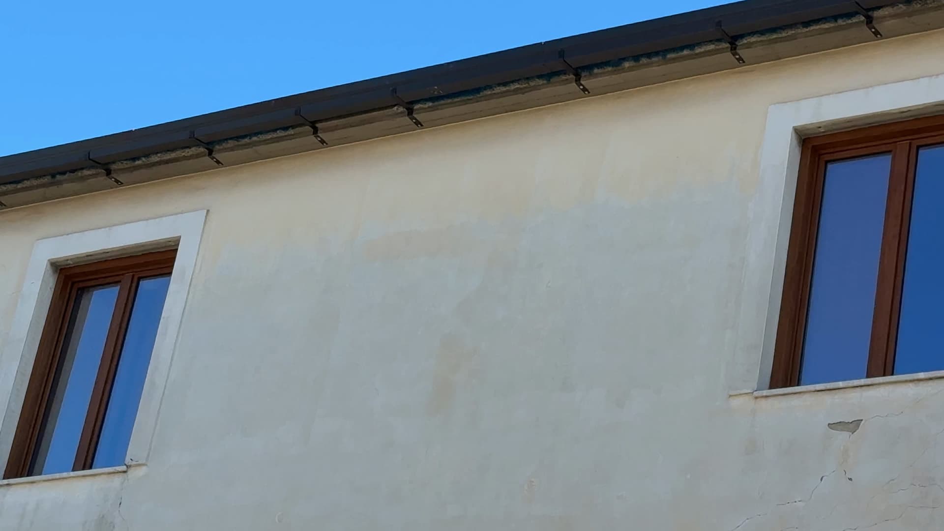 Dopo i lavori: la gronda nuova, scura e squadrata, corre lungo il bordo del tetto sulle staffe esterne.
